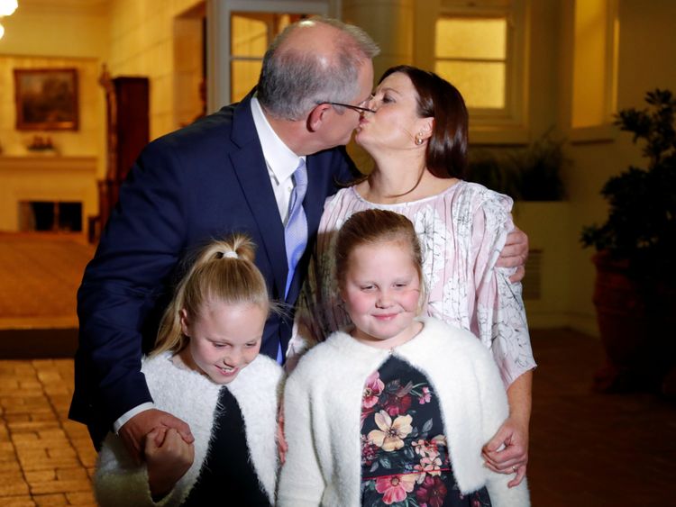  Scott Morrison kisses his wife Jenny as he stands with his doughters after the swearing-in ceremony
