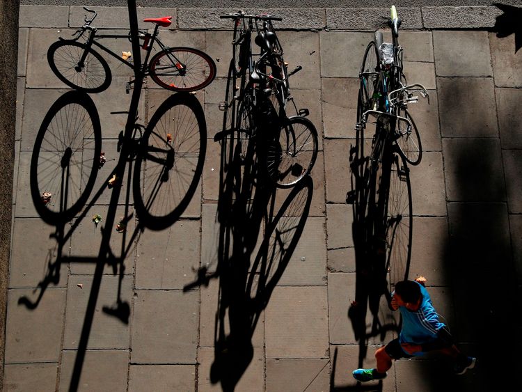 A jogger passes the shadows of bicycles as he runs along the Embankment, pictured from Waterloo Bridge in central London on November 6, 2017. / AFP PHOTO / Adrian DENNIS (Photo credit should read ADRIAN DENNIS/AFP/Getty Images)