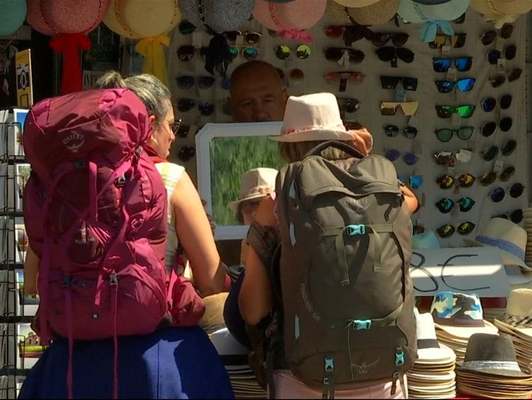 Two backpackers stop to buy hats in Madrid