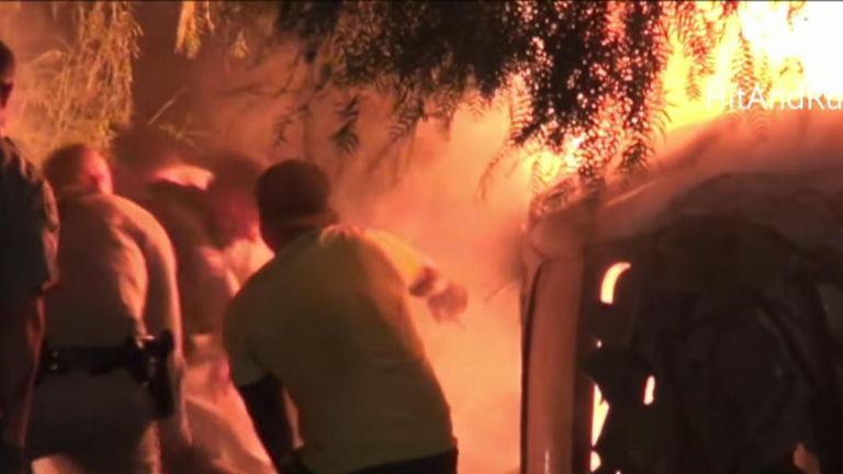 Passers-by and police rescued an unconscious man from the burning wreckage of a car crash in California.