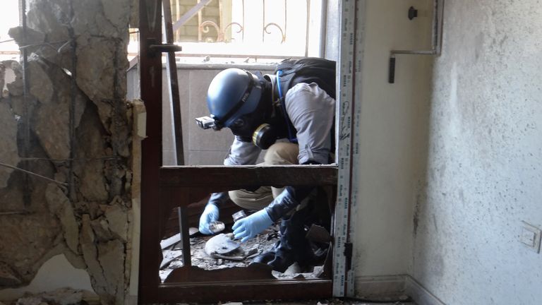 A UN arms expert collects samples in Ghouta during the investigation into the chemical weapons strike 