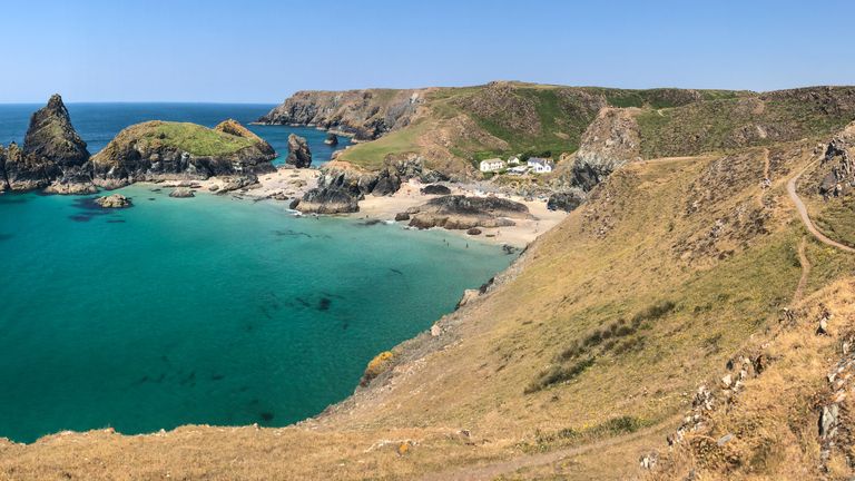 People enjoy the fine weather as they visit Kynance Cove on the Lizard Peninsula