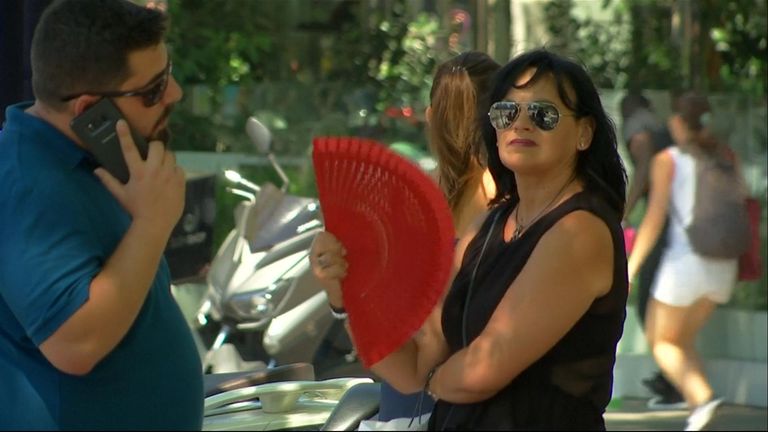 A woman fans herself as the temperatures soar above 40C