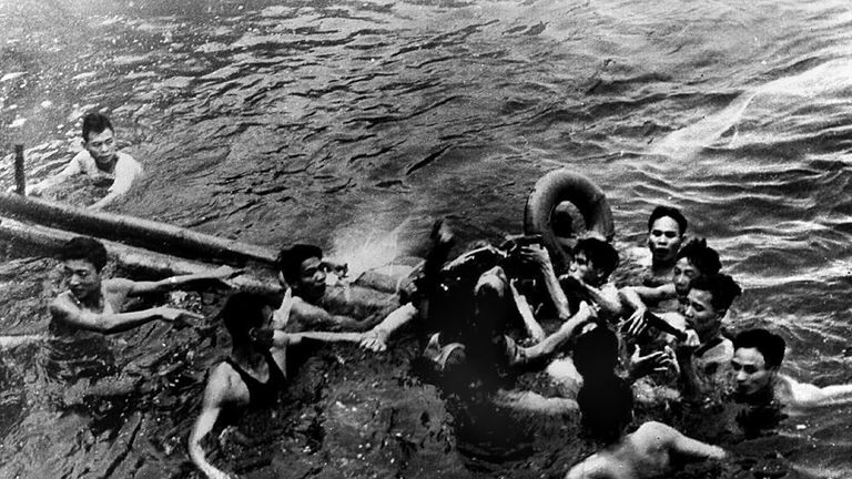 John McCain (C) being pulled from a lake in Hanoi after his Navy warplane was downed