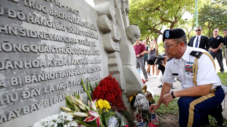Military Attache Ton Tuan from US Embassy places incense at the McCain Memorial in Hanoi.