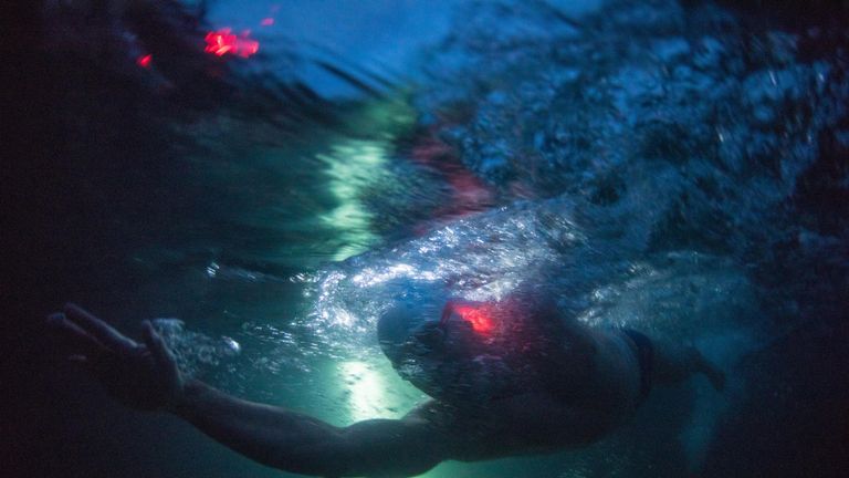 The endurance swimmer has had glowsticks attached to aid visibility