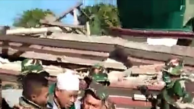 Indonesian soldiers on Monday rescued a man who was trapped beneath the rubble of a mosque which collapsed during a powerful quake