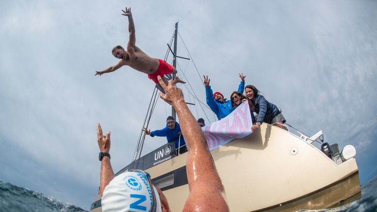 Lewis&#39; crew celebrated passing halfway with a banner and a song while 1st mate, Rowan, jumped in. Pic: Lewis Pugh