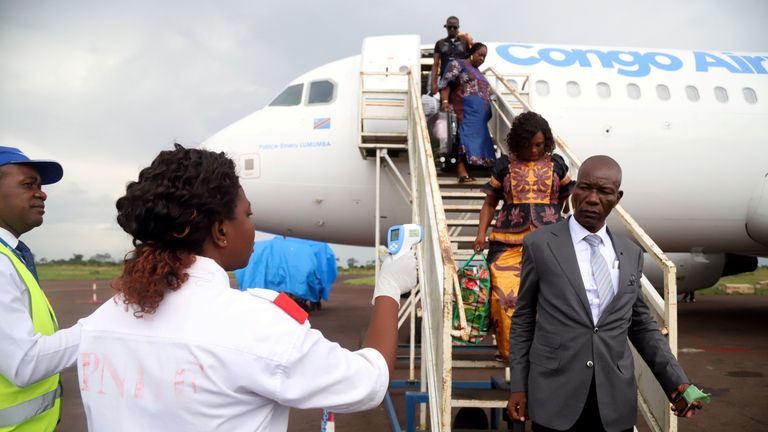 Congolese health workers check the temperature of passengers disembarking from a Congo Airways plane in Mbandaka, Democratic Republic of Congo May 19, 2018