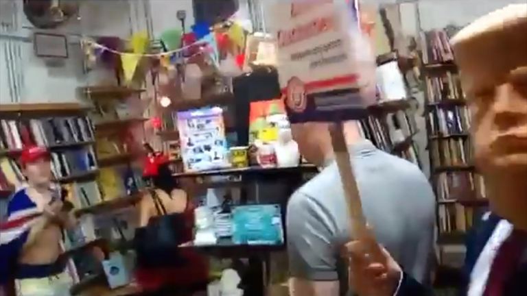 Far-right protesters including man in Trump mask attack socialist bookshop while chanting about Muslims