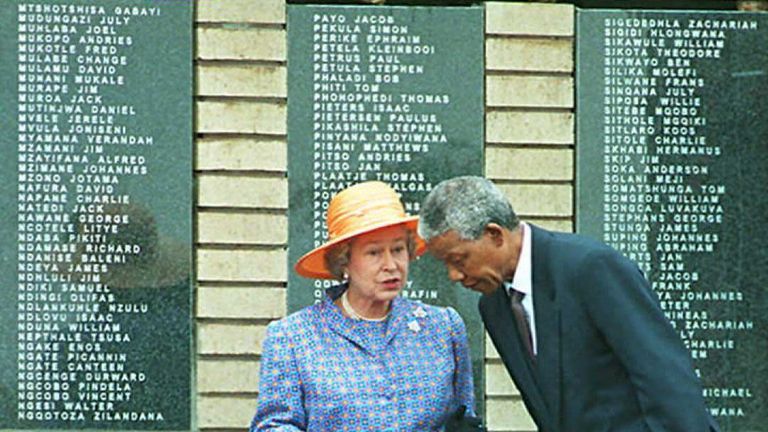 SOWETO, SOUTH AFRICA - MARCH 23: President Nelson Mandela leans forward as he speaks with Queen Elizabeth II at Avalon cemetery in Soweto, outside Johannesburg 23 March. The Queen unveiled a memorial to commemorate, 600 black soldiers who died when the SS-Mendi sank in the English Channel during World War I , in 1917. (COLOR KEY: Mandela wears dark blue suit). AFP PHOTO (Photo credit should read WALTER DHLADHLA/AFP/Getty Images)