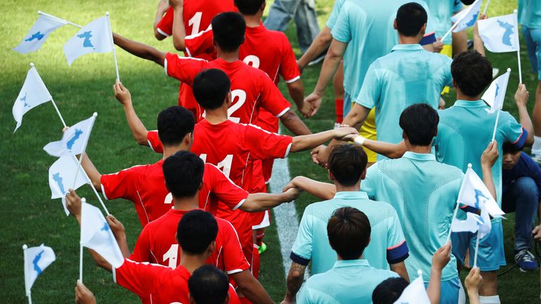 North and South Korean workers arrive for their friendly football match