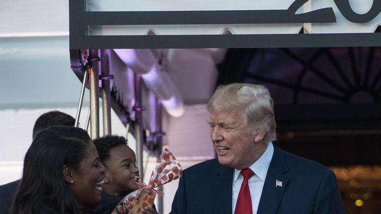 Mr Trump speaks with Ms Newman as he hands out candy to children during a Halloween event