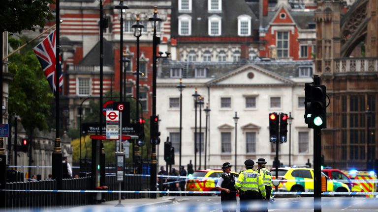Police stand in the street after a car crashed outside the Houses of Parliament 