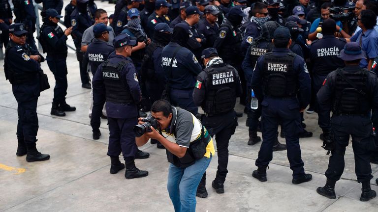 A Mexican photojournalist works during a protest of police officers in Chilpancingo, Guerrero state, Mexico, on May 30, 2017