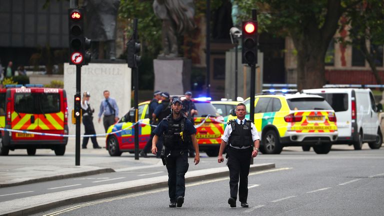 Police patrol the scene outside parliament where a car is said to have crashed