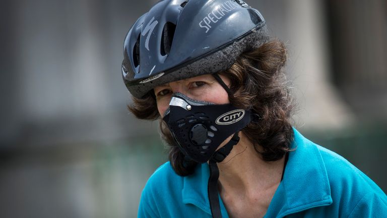 A female cyclist in London wears a protective mask to avoid breathing in toxic air
