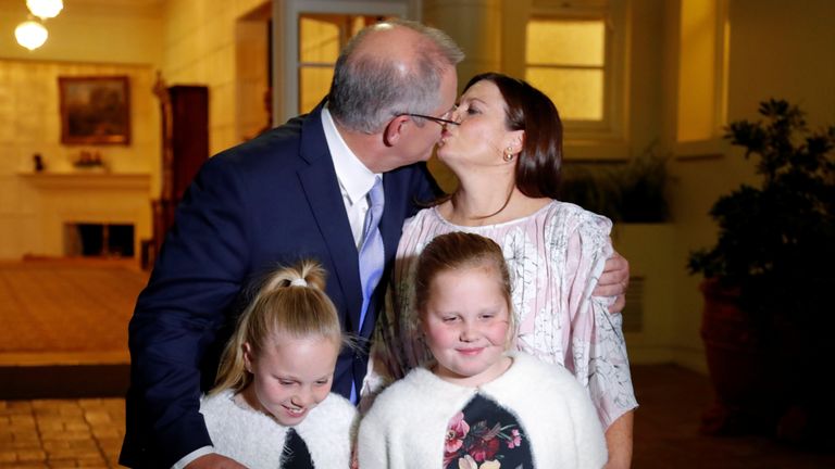  Scott Morrison kisses his wife Jenny as he stands with his doughters after the swearing-in ceremony