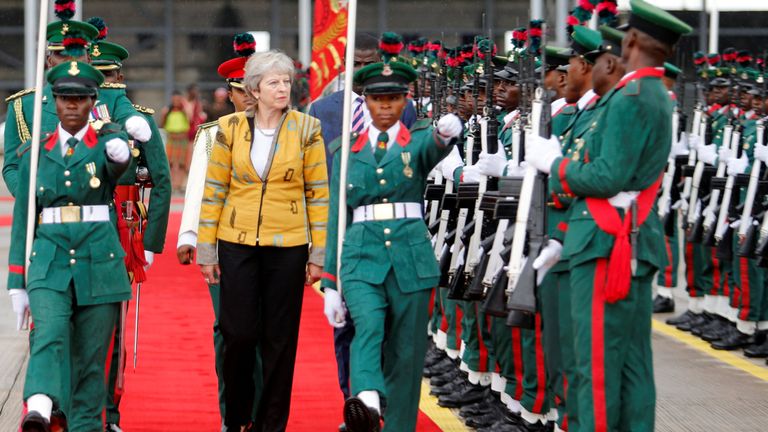 Theresa May inspects a Guard of Honour as she arrives in Abuja, Nigeria
