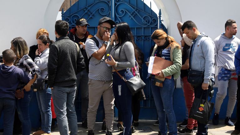 Venezuelan migrants queue outside the immigration office in Lima, Peru