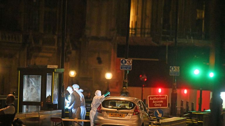 Forensic officers analyse the car that crashed into security barriers outside Parliament