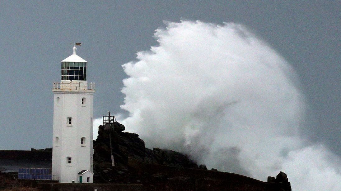 Waves crash against Godrevy Lighthouse on Godrevy Island in St Ives Bay, Cornwall