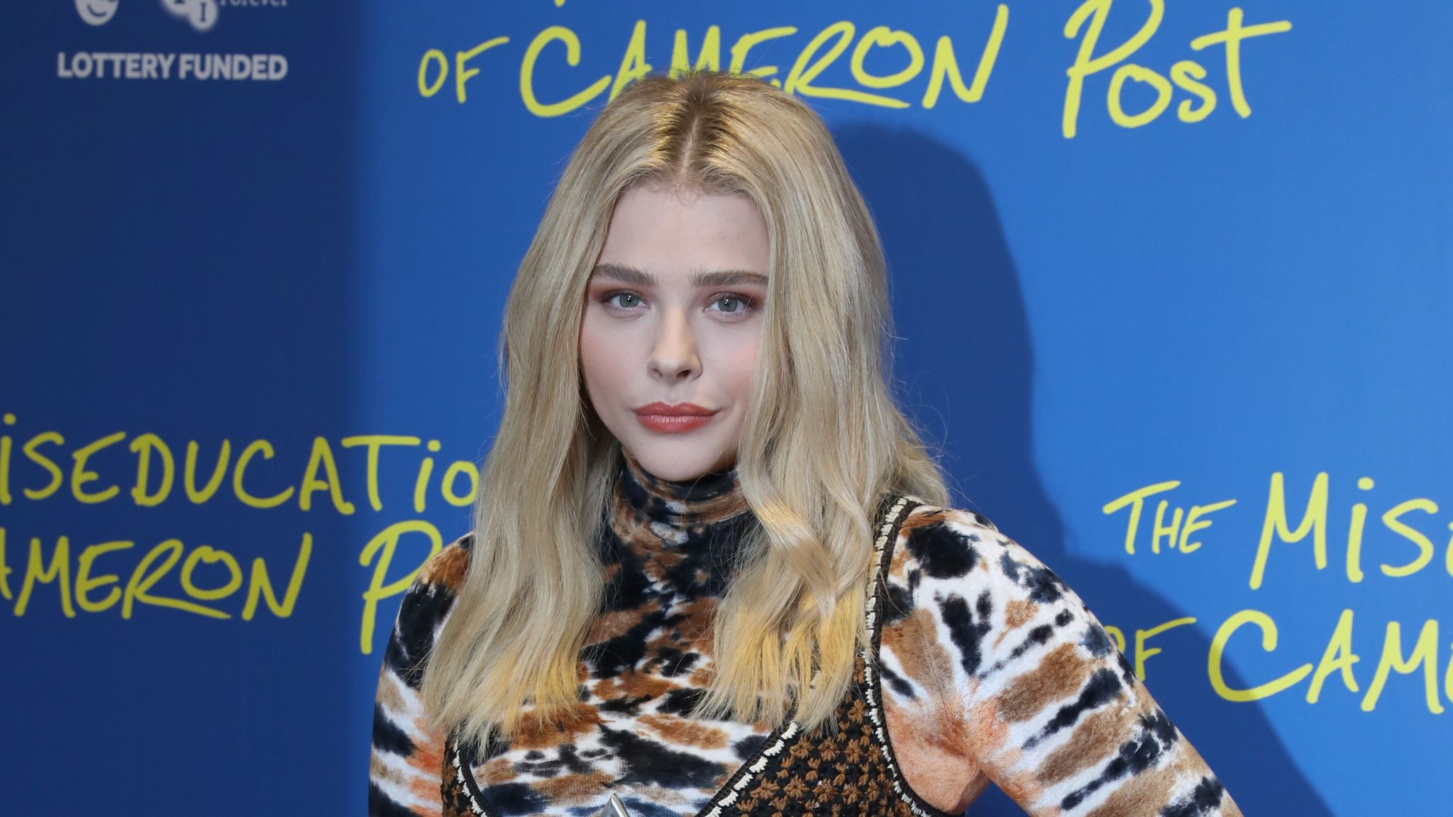 Chloe Grace Moretz is seen wearing a black coat and yellow scarf