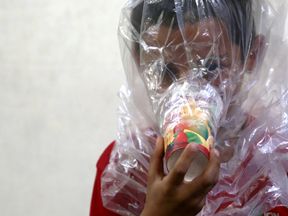 A boy tries on an improvised gas mask in Idlib