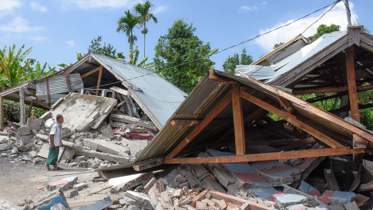 An Indonesian man examines the remains of houses, after a 6.4 magnitude earthquake struck, in Lombok 