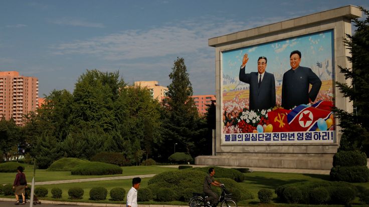 Residents pass by a painting featuring late North Korean leaders Kim Il-sung (L) and Kim Jong-il ahead of 70th anniversary of North Korea&#39;s foundation in Pyongyang
