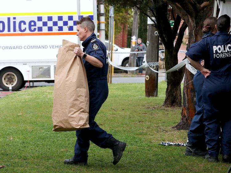 A police officer carries a bag from a property where five people were found dead in a suburb of Perth, Australia, September 10, 2018. AAP/Richard Wainwright/via REUTERS ATTENTION EDITORS - THIS IMAGE WAS PROVIDED BY A THIRD PARTY. NO RESALES. NO ARCHIVE. AUSTRALIA OUT. NEW ZEALAND OUT. NO COMMERCIAL OR EDITORIAL SALES IN NEW ZEALAND. NO COMMERCIAL OR EDITORIAL SALES IN AUSTRALIA.
