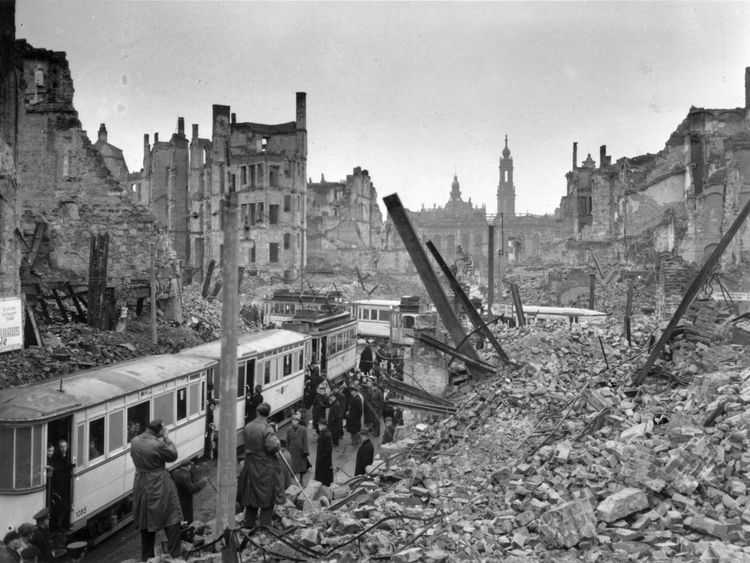 Germans board trams in the midst of ruins left by an Allied air raid on Johannstrasse, Dresden