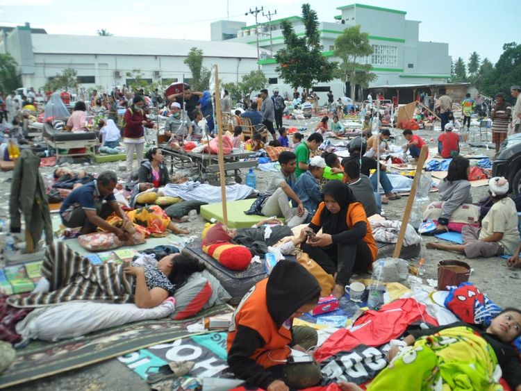 Medical team members help patients outside a hospital after an earthquake and a tsunami hit Palu