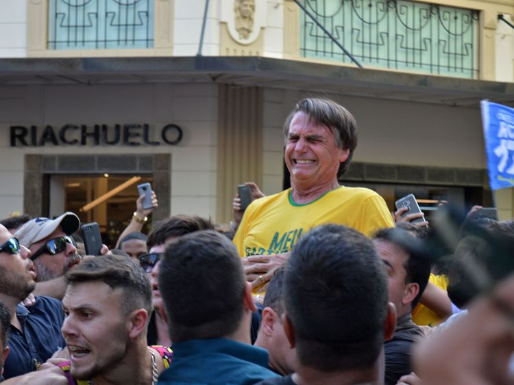Brazilian right-wing presidential candidate Jair Bolsonaro gestures after being stabbed in the stomach
