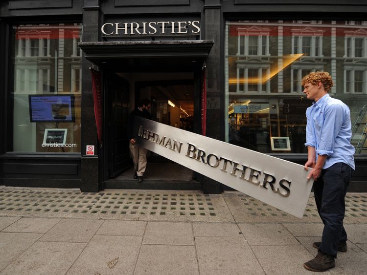 Employees pose for photographers with a Lehman Brothers company sign at Christie's auction house in London on September 24, 2010. The sign will be sold as part of the 'Lehman Brothers: Artwork and Ephemera' sale in London on September 29. AFP PHOTO / BEN STANSALL (Photo credit should read BEN STANSALL/AFP/Getty Images)
