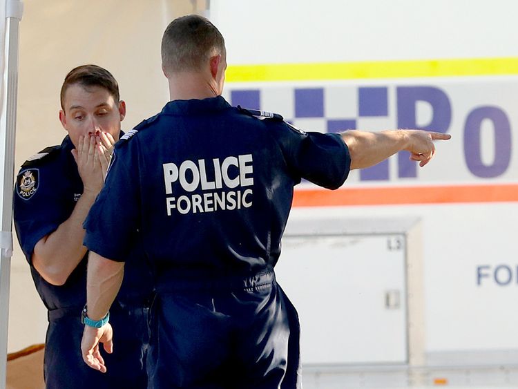 Police officers appear in shock after the bodies were found at the Bedford property