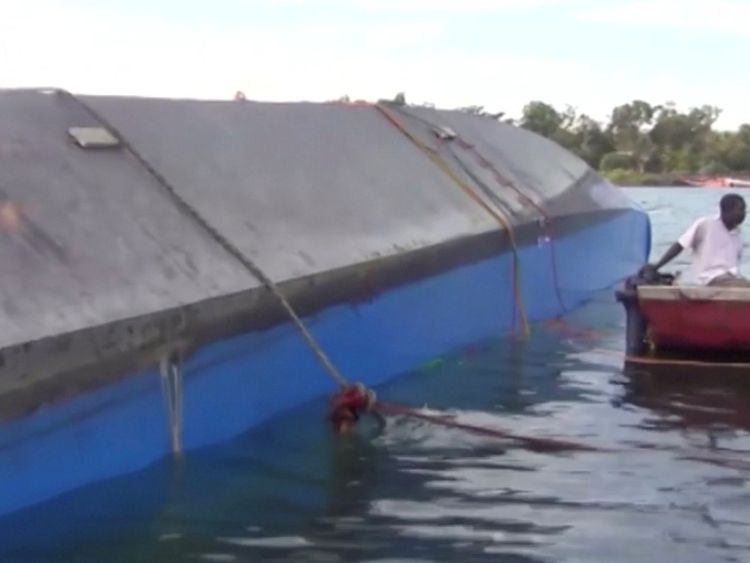 Rescue workers examine the hull of the ferry that overturned in Lake Victoria