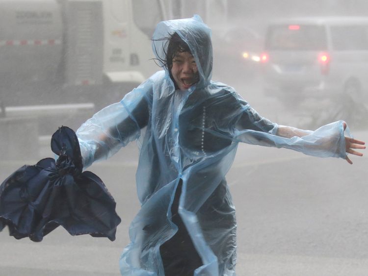 A woman runs in Shenzen as Typhoon Mangkhut arrives in China