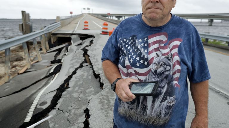 Residents stop to photograph a section of the Highway 17 exit ramp that remains closed a day after Hurricane Florence&#39;s storm surge washed it out September 15, 2018 in New Bern, North Carolina