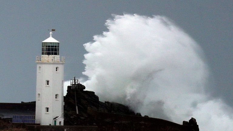 Waves crash against Godrevy Lighthouse on Godrevy Island in St Ives Bay, Cornwall