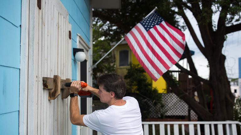 A man helps board up Aussie Island surf shop on September 11, 2018 in Wrightsville, North Carolina in anticipation of Hurricane Florence&#39;s high storm surge