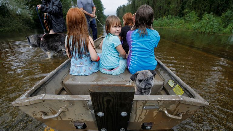 Children and pets rescued from rising flood waters in the aftermath of Hurricane Florence in Leland, North Carolina
