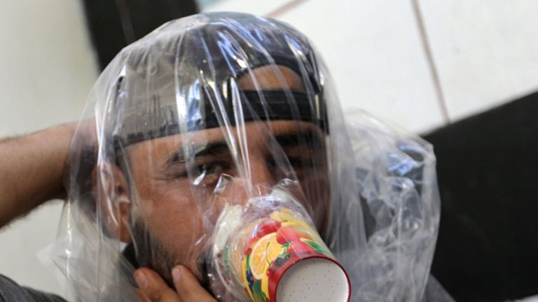 Hudhayfa al-Shahad tries an improvised gas mask in Idlib, Syria 