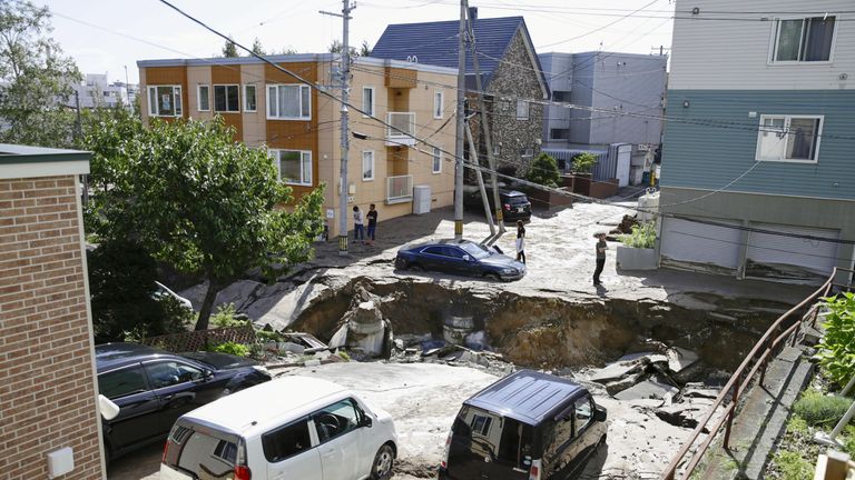 People look at an area damaged by an earthquake in Sapporo in Japan's northern island of Hokkaido