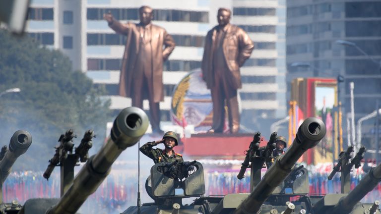 Korean People&#39;s Army (KPA) soldiers salute as they ride tanks during a military parade and mass rally on Kim Il Sung square in Pyongyang on September 9, 2018