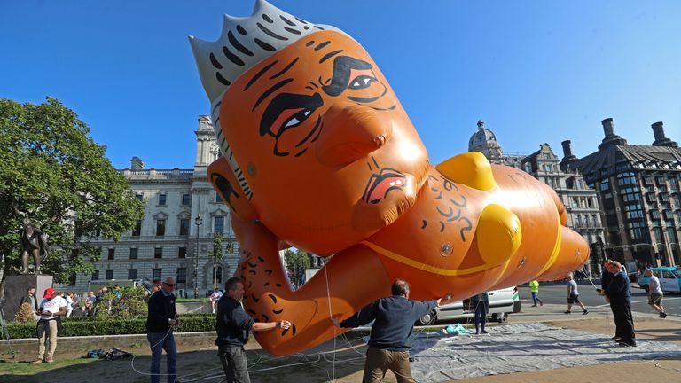 Demonstrators launch a giant bikini-clad blimp of London Mayor Sadiq Khan over Parliament Square