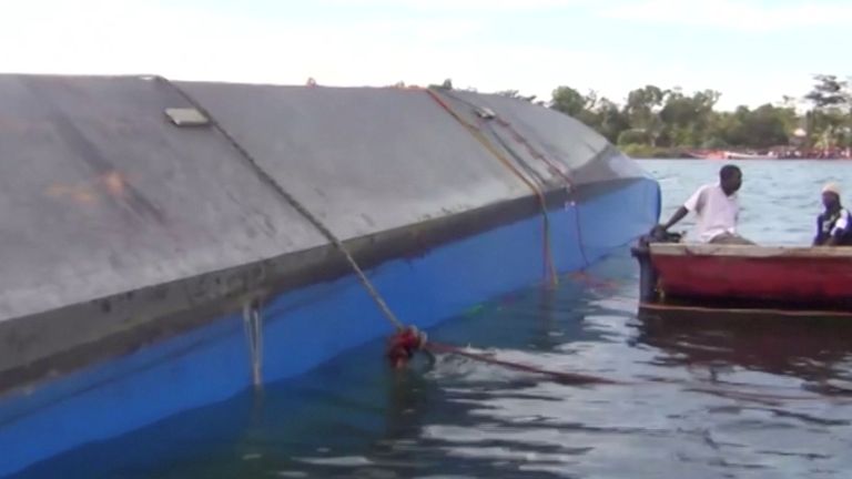 Rescue workers examine the hull of the ferry that overturned in Lake Victoria
