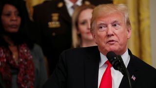 U.S. President Donald Trump listens as first lady Melania Trump speaks about the apparent bombs sent in packages addressed to Democratic political figures in New York, Washington and Florida during an event in the East Room of the White House on the administration efforts to "combat the opioid crisis" in Washington, U.S., October 24, 2018