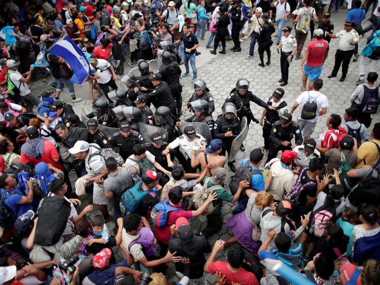 Honduran migrants storm a border checkpoint to cross into Mexico, in Tecun Uman, Guatemala