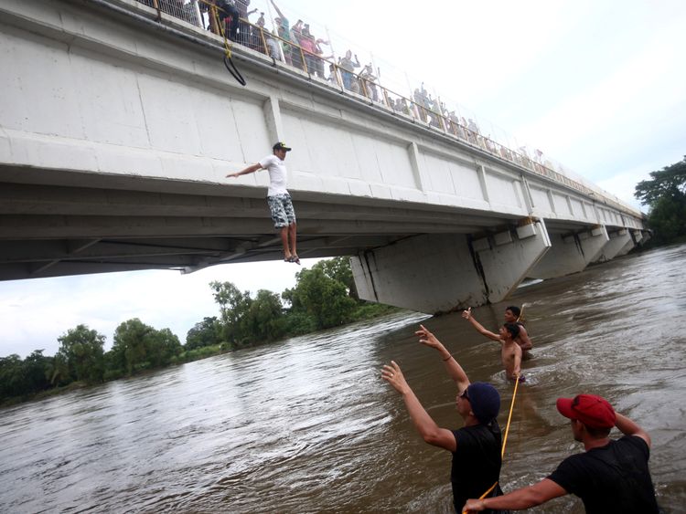 A Honduran jumps from a bridge to avoid a Guatemala-Mexico border checkpoint